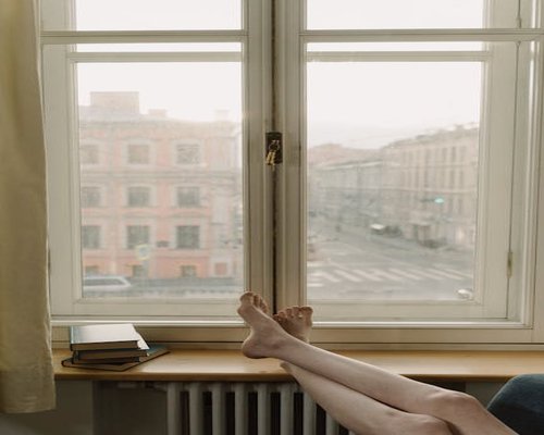 Person relaxing at home by a window